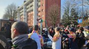Il passaggio della fiamma olimpica tra due tedofori nella tappa di Segrate verso Milano Cortina 2026