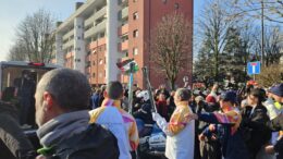 Il passaggio della fiamma olimpica tra due tedofori nella tappa di Segrate verso Milano Cortina 2026